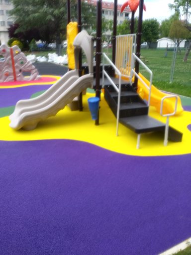 parques infantiles Tobogán y escaleras en un parque infantil con suelo de goma amarilla y morada.